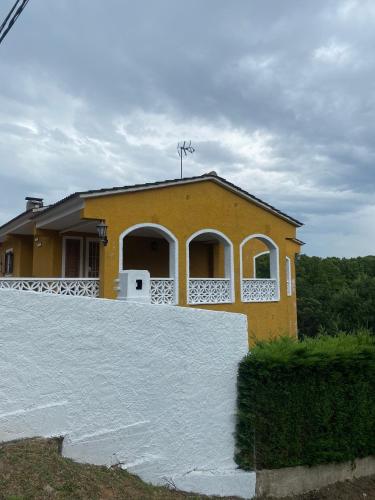 a yellow house with a white fence in front of it at Charming 8-Bed Villa in Girona in Girona