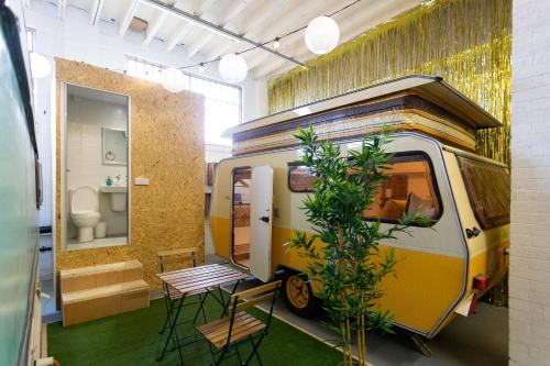 a yellow and white van in a room with a toilet at Towed Town Camping in Bristol