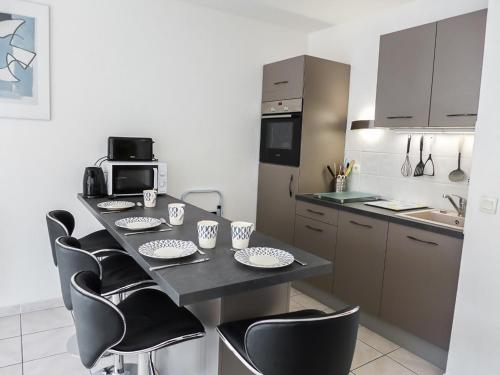 - une cuisine avec une table, des chaises et un comptoir dans l'établissement Apartment Les Calanques du Parc-2 by Interhome, à Saint-Aygulf