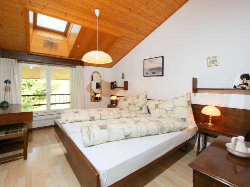 a large white bed in a room with wooden ceilings at Apartment Ringstrasse - Utoring-46 by Interhome in Leukerbad