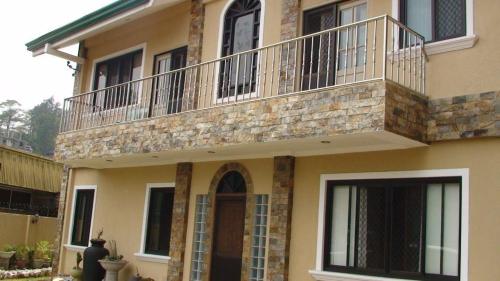 a building with a balcony on top of it at Lyn's Do Drop Inn Transient House in Baguio