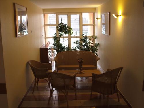 a dining room with a table and chairs and windows at Marben Panzió in Hegykő