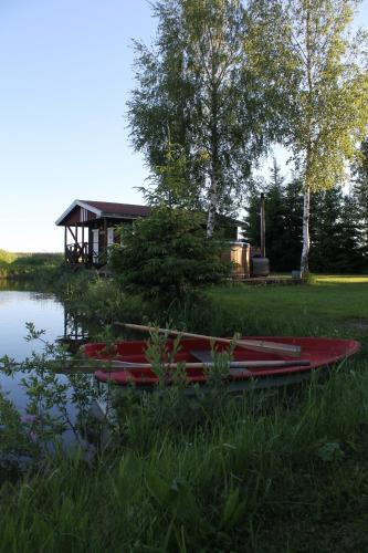a group of red canoes sitting in the grass next to a building at Beautiful private cabin near Tartu in Külitse