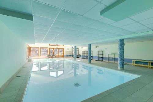une grande piscine dans un grand bâtiment dans l'établissement Le Chevreuil - 3 chambres, terrasse, piscine, à Flumet