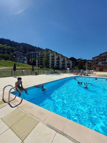 un groupe de personnes dans une piscine dans l'établissement Chalet Côté Cœur, La Tania, with Outdoor Hot Tub and 7 Ensuite Rooms, à La Tania