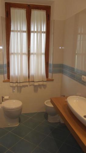 a bathroom with two toilets and a sink and a window at Agriturismo San Galgano in Chiusdino
