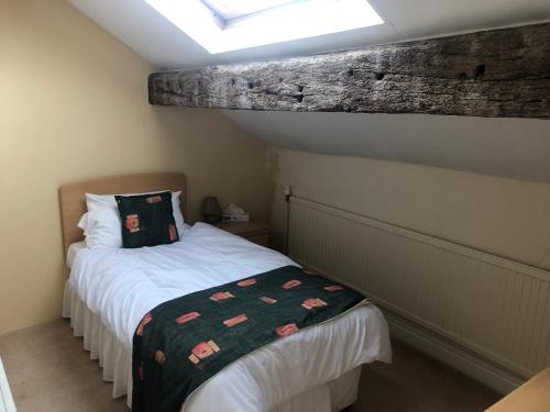 a small bedroom with a bed and a skylight at Whalley Abbey - Christian Retreat House offering B&B in Whalley