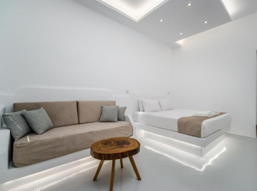a white living room with a couch and a table at Serenità Luxury Suites in Akrotiri