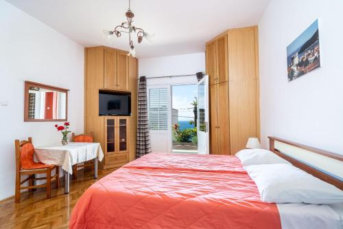 Un dormitorio con una cama, una mesa y un televisor. en Apartments Kazo, en Dubrovnik