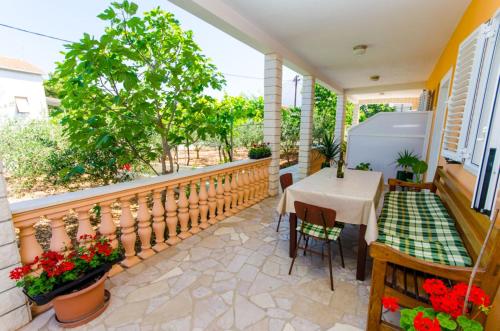 a balcony with a table and chairs on a porch at Apartments Ivana in Trogir