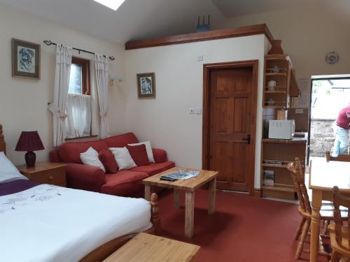 a bedroom with a bed and a couch and a table at Beautiful 1-Bed Cottage in Trellech in Trelleck