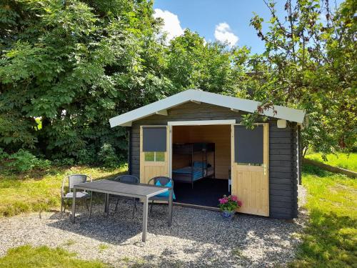 a small shed with a table and a bed in it at Camping Weides in Küps