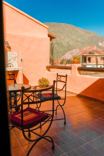 a patio with two chairs and a table on a roof at Colores de Purmamarca in Purmamarca