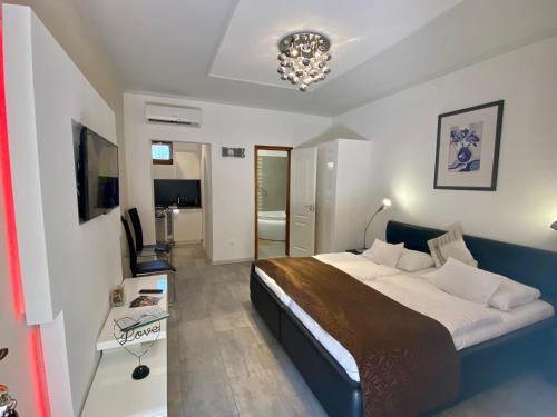 a bedroom with a large bed and a chandelier at Bajor Panzió Bük-Bükfürdő, Adults Friendly 12 Plus in Bük