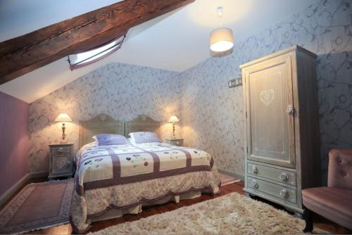 - une chambre avec un grand lit et une chaise dans l'établissement Le Château de Vernières, à Talizat