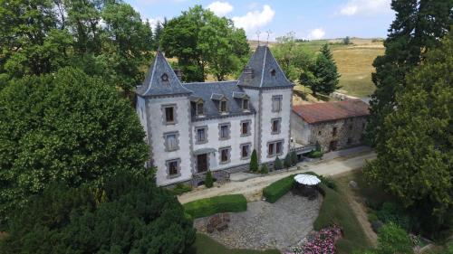 - une vue aérienne sur une vieille maison arborée dans l'établissement Le Château de Vernières, à Talizat