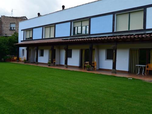 une maison avec une pelouse devant elle dans l'établissement Apartamentos La Peinada, à Villarejo
