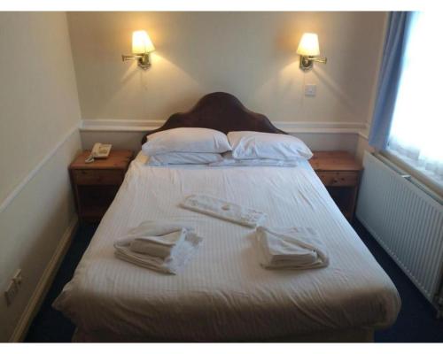 a bedroom with a bed with two towels on it at Diamond Hotel in Torquay