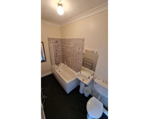 a bathroom with a tub and a sink and a toilet at Diamond Hotel in Torquay