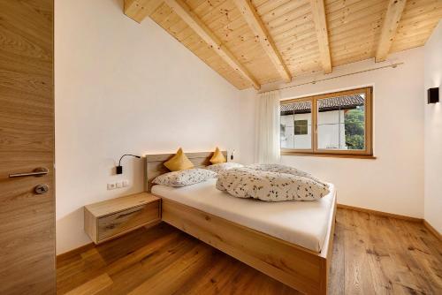 een slaapkamer met een bed in een kamer met een raam bij Unterötzbauerhof - Fewo Rosenblick in Tirolo
