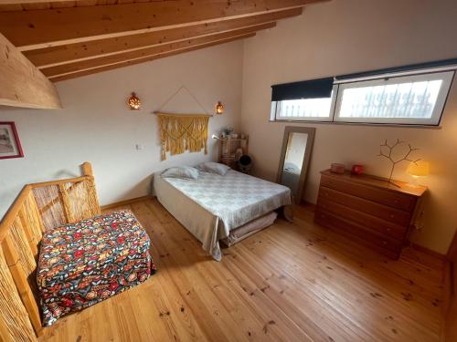 ein Schlafzimmer mit einem Bett, einer Kommode und einem Fenster in der Unterkunft CASA BIKAS in Barão de São Miguel