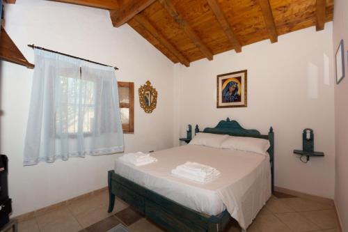 a bedroom with a bed and a window at Villa L'Oliveto in Oliena