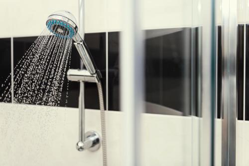 a shower head with water coming out of it at Hotel Ostende in Chocerady