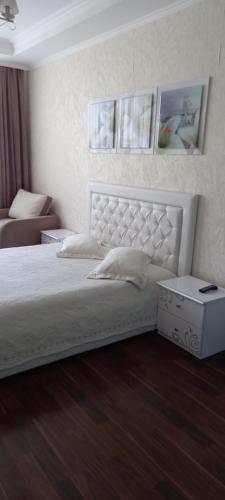 a bedroom with a white bed and a couch at Альтаир1 in Odesa