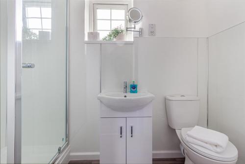 a white bathroom with a toilet and a sink at Guest Homes - New Street Accommodation in Worcester