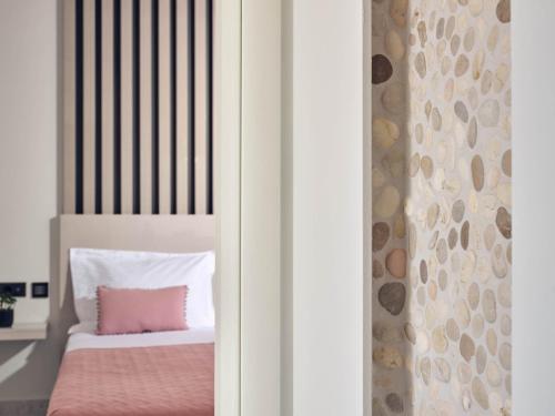 a bedroom with a bed with a pink blanket at SAVVAS & JOANNA BOUTIQUE in Laganas