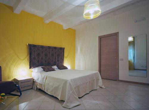 a bedroom with a white bed and a yellow wall at Casa Canale in Reggio di Calabria