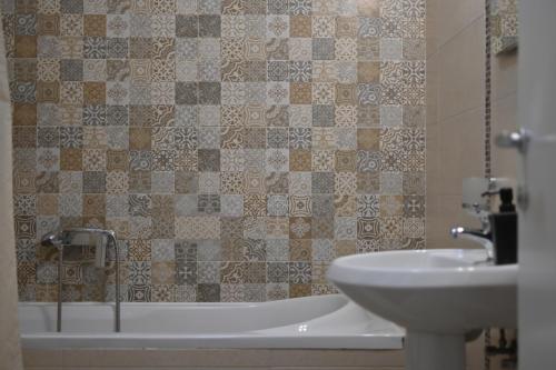 a bathroom with a sink and a bath tub next to a toilet at New Apartment CRISTAL in the city centre in Novi Sad