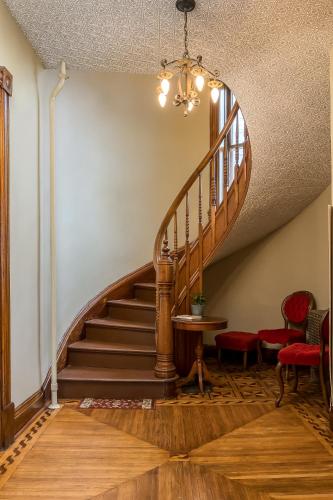a staircase in a house with red chairs and a table at Moulin Rouge House Bed and Breakfast in Mankato