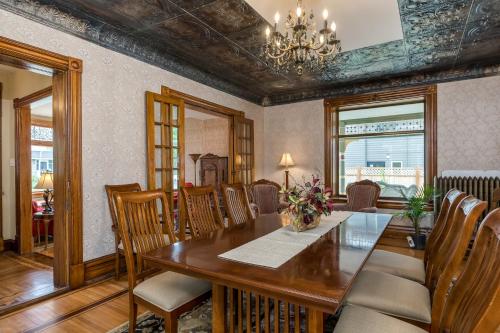 a dining room with a wooden table and chairs at Moulin Rouge House Bed and Breakfast in Mankato