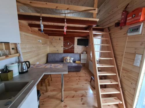 a room with a couch and a staircase in a tiny house at Siedlisko nr 4E i 4F nad jeziorem Skarlińskim, jezioro, mazury, domki letniskowe, bania in Kurzętnik