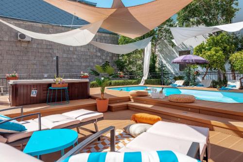 a patio with a swimming pool with chairs and a table at Evala luxury rooms with pool and garden in Split