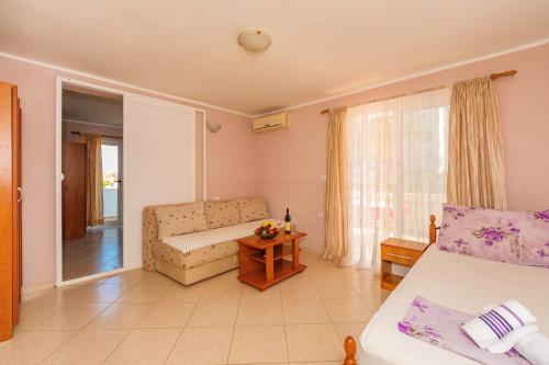 een kamer met een bed, een bank en een raam bij Guest House Edita in Ulcinj