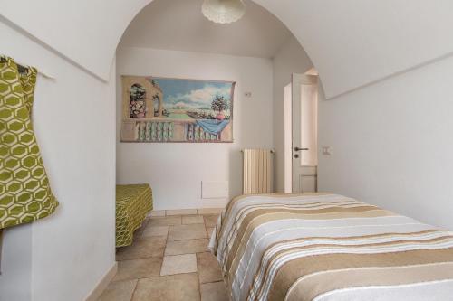 um quarto com uma cama e um quadro na parede em Trullo Ventura by BarbarHouse em Locorotondo