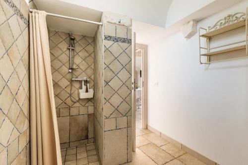 uma casa de banho com um chuveiro e uma porta de vidro em Trullo Ventura by BarbarHouse em Locorotondo