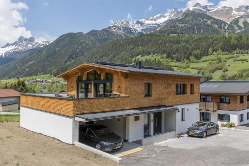 een huis met een auto geparkeerd op een parkeerplaats bij Chalet Vega - Arlberg Holiday Home in Pettneu am Arlberg