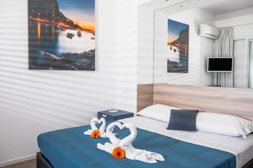 a bedroom with a bed with two swans towels at A Tonnara in Cefalù