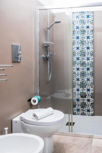 a bathroom with a toilet and a glass shower at A Tonnara in Cefalù