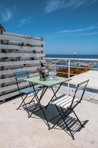 a green table and chairs on a balcony with the beach at A Tonnara in Cefalù