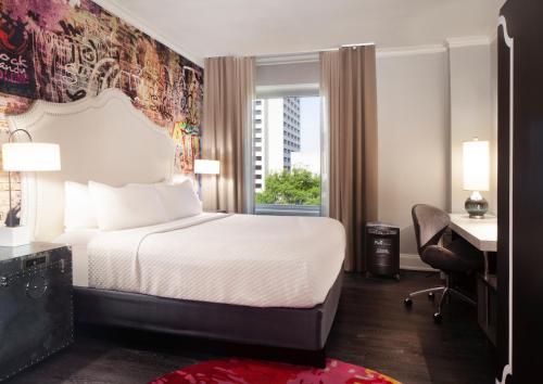 ein Hotelzimmer mit einem Bett, einem Schreibtisch und einem Fenster in der Unterkunft Hotel Indigo Atlanta Midtown, an IHG Hotel in Atlanta