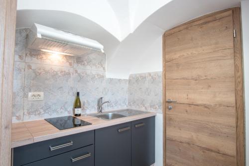 cocina con fregadero y puerta de madera en Vila Radolca apartments & rooms, en Radovljica