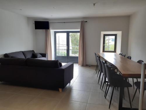 un salon avec un canapé, une table et des chaises dans l'établissement Le Bouchatou (meublé touristique neuf)***, à Saint-Front