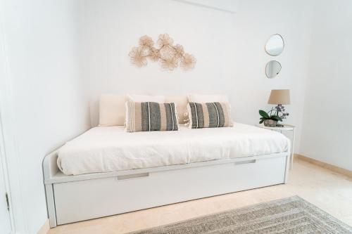 een wit bed met kussens in een slaapkamer bij Polo Apartments 2A in Marbella