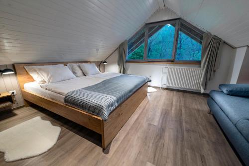 a bedroom with a bed and a couch at Apartma in sobe PR'OBJAN in Bohinj
