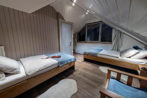 ein Zimmer mit 2 Betten und einem Stuhl darin in der Unterkunft Apartma in sobe PR'OBJAN in Bohinj