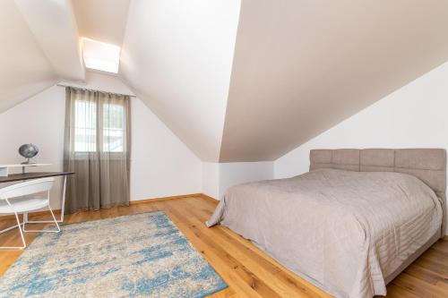 a bedroom with a bed and a desk and a window at Lossi Old Town Apartment in Tartu